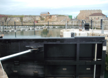 Water Control gate at Seaham Harbour. The black steel gate in its closed position, with hydraulic arm extended.