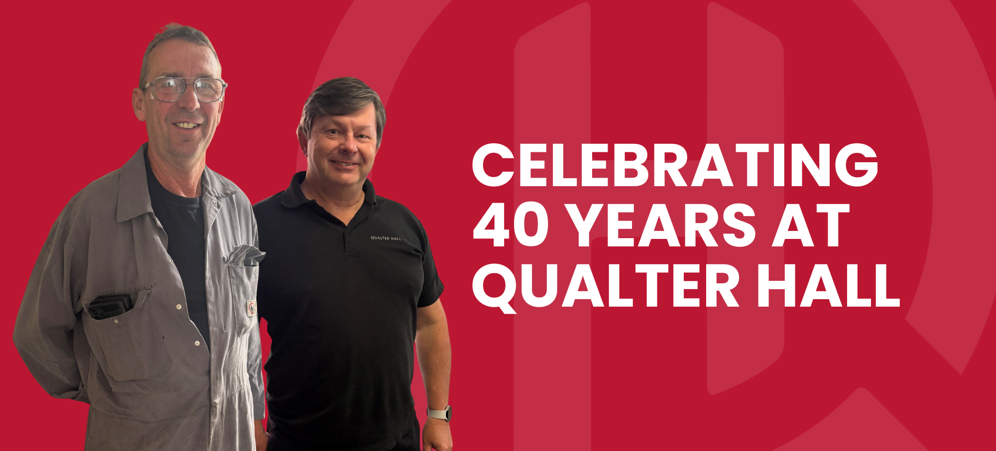 Carl smiles and wears his grey Qualter Hall workshop overalls with a black t-shirt and protective glasses. Andrew stands beside him, wearing a black branded Qualter Hall polo shirt.