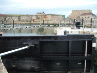 Water Control gate at Seaham Harbour. The black steel gate in its closed position, with hydraulic arm extended.
